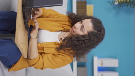 Vertical-video-of-Young-woman-looking-at-laptop-gets-frustrated.